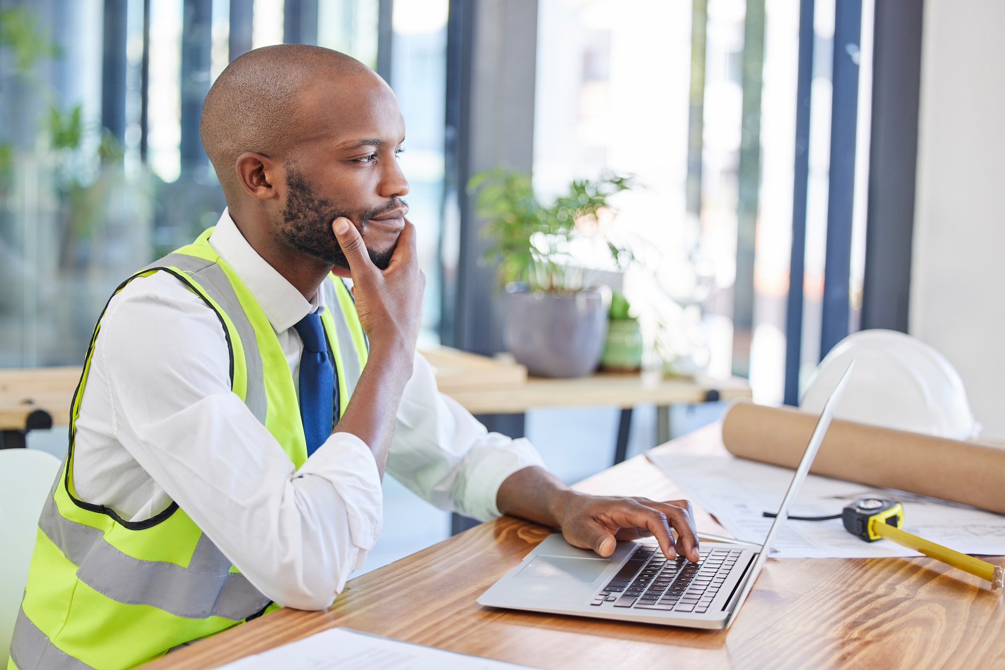 Architect, laptop and man thinking or planning building or construction idea with online research. Architect, laptop and man thinking or planning building or construction idea with online research.