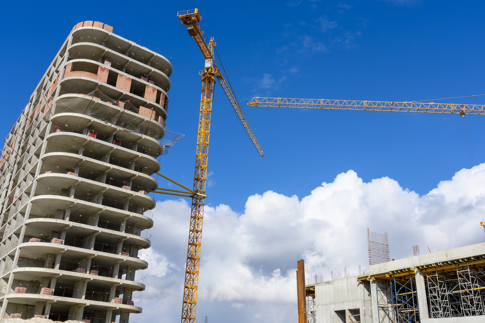 Crane and building construction site against blue sky