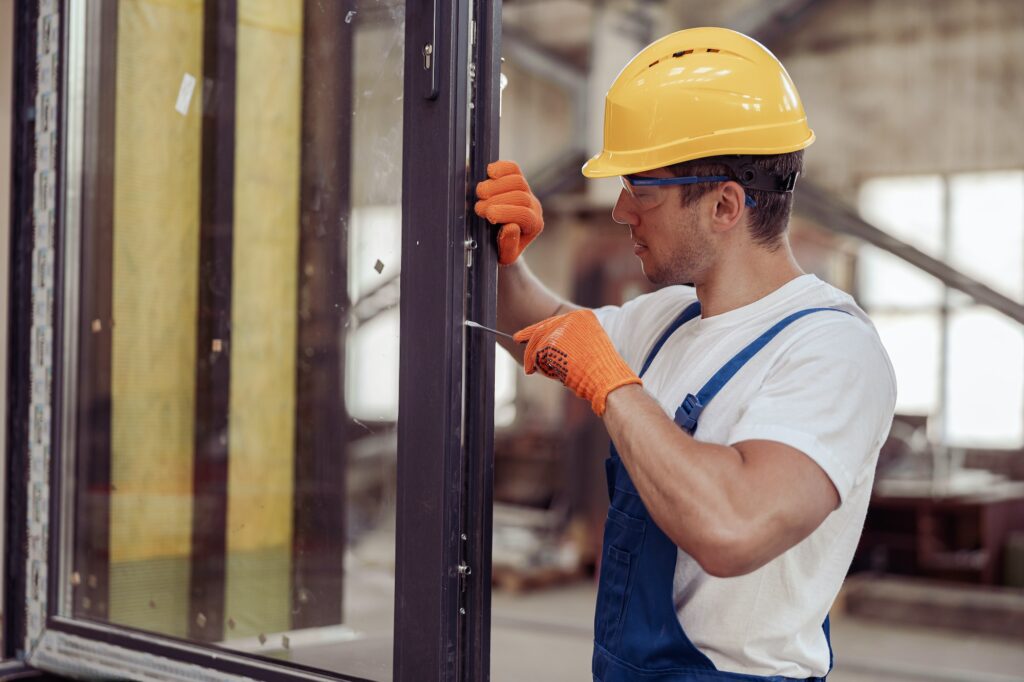 Male worker fixing door in building under construction